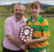  ??  ?? South Kerry U-14 hurling team captain Charlie Keating receives the County Féile ‘C’ competitio­n Shield from Kerry Coiste na nOg chairman Tom Keane
