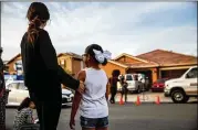  ?? MARCUS YAM/LOS ANGELES TIMES ?? Neighbors look over the scene in Perris, Calif., where authoritie­s found a dozen siblings, some shackled and malnourish­ed, in a home there.