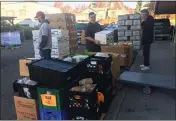  ??  ?? Pastor Mike Brown, middle, helps carry food after a Food Bank delivery at First Baptist Church in downtown Vallejo.