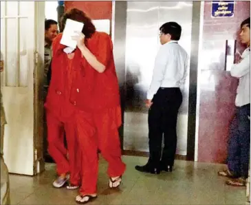  ?? SUPPLIED ?? Australian nurse Tammy Davis-Charles (centre left), hides her face as she is escorted out of Phnom Penh Municipal court yesterday.