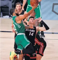  ?? KEVIN C. COX/GETTY IMAGES ?? The Boston Celtics’ Jayson Tatum (0) drives to the basket Saturday against the Miami Heat’s Tyler Herro (14) during the fourth quarter. The Celtics won 117-106 to reduce the Heat’s Eastern Conference finals lead to 2-1.