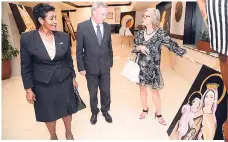  ??  ?? Honourary consul of Thailand, Thalila Lyn (right), discusses Ambassador German’s artwork with Belgium Ambassador Guy Sevrin, while Marcia Gilbert-Roberts looks on.