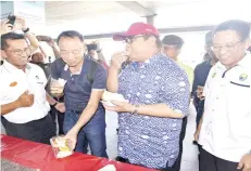  ??  ?? Yahya enjoying durian with one of the tourists at Kota Kinabalu Internatio­nal Airport.