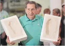  ?? FELIPE DANA/THE ASSOCIATED PRESS FILES ?? Ghiggia holds prints of his feet in 2009 to placed on Brazil’s Soccer Walk of Fame in Maracana stadium.