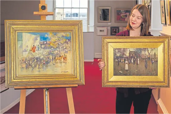  ?? Picture: Paul Reid. ?? Carly Shearer of Lyon &amp; Turnbull holds a painting by James Watterston Herald entitled Sunday Morning, with his work The Travelling Theatre, Buffalo Bill at Arbroath, on the left.