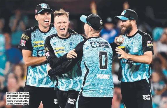  ?? ?? Matthew Kuhnemann of the Heat celebrates with teammates after taking a wicket at the Gabba. Picture: Getty