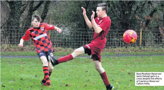  ??  ?? Bancffosfe­len Reserves’ Ianto Dafydd gets in a cross despite the efforts of Caerbryn Reserves’ Callum Holly.