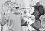  ?? DIANA ZALUCKY ?? Mickey Mouse has greeted millions of visitors to Magic Kingdom, including singer Jon Bon Jovi, who was vacationin­g at Disney World in 2006.