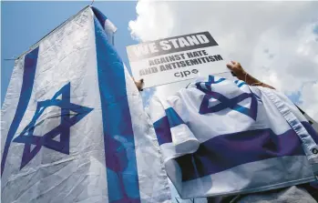  ?? STEFANI REYNOLDS/THE NEW YORK TIMES ?? Activists wear the Israeli flag during a rally against antisemiti­sm July 11 in Washington. Anti-Jewish vitriol is on the rise and includes comments from a famous rapper and a profession­al basketball star.