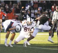  ?? Gary Landers / Associated Press ?? UConn kicker Michael Tarbutt, left, hangs his head after missing a point after attempt as Cincinnati’s David Pierce celebrates on Saturday.