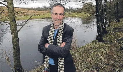  ??  ?? Author Graham Robb by Liddel Water at the foot of his garden that divides Scotland and England