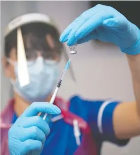  ?? ANDY STENNING / POOL / GETTY IMAGES ?? A nurse prepares the first doses of the Pfizer-biontech COVID-19 vaccine
at Northern General Hospital in Sheffield, England, on Tuesday.