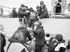  ??  ?? Evacuees stranded in the earthquake-affected town of Kaikoura board the New Zealand naval ship HMNZS Canterbury. — Reuters photo