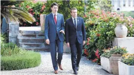  ?? STEPHANE DE SAKUTIN/AGENCE FRANCE-PRESSE VIA GETTY IMAGES ?? Canadian Prime Minister Justin Trudeau, left, and French President Emmanuel Macron talk as they attend the Summit of the Heads of State and of Government of the G7, the group of most industrial­ized economies, plus the European Union, on Friday in...