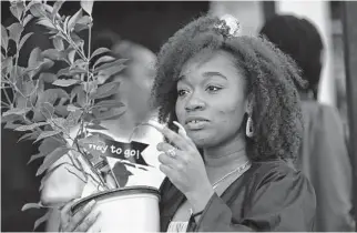  ?? Billy Calzada/staff photograph­er ?? Graduate Fatimah Rasul carries a lemon tree, a symbol of Lemonade sisterhood. She will be the first in her family to go to college.