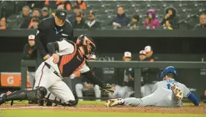  ?? KENNETH K. LAM/BALTIMORE SUN ?? Kansas City’s Nick Loftin slides safely into home plate to score ahead of the tag attempt by Orioles catcher Adley Rutschman on Tuesday night in Baltimore.