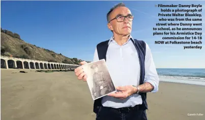  ?? Gareth Fuller ?? &gt; Filmmaker Danny Boyle holds a photograph of Private Walter Bleakley, who was from the same street where Danny went to school, as he announces plans for his Armistice Day commission for 14-18 NOW at Folkestone beach yesterday