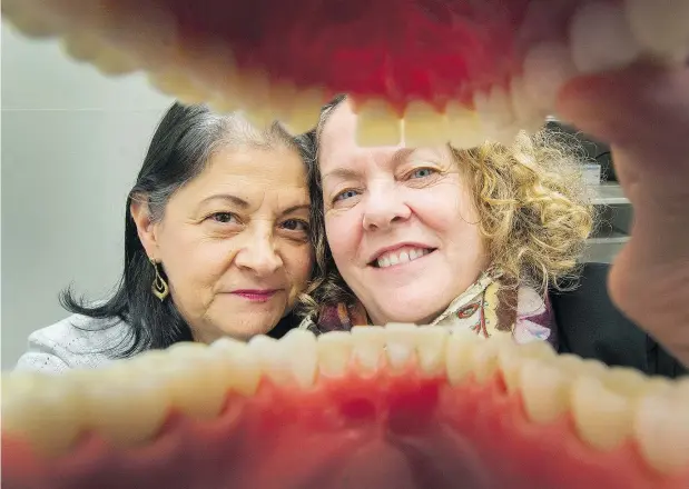  ?? ?? Maria Botero, left, with executive director Nicole LeMire, is manager of the REACH Dental Clinic on Commercial Drive, part of a non-profit community health centre that often gets calls from people asking about prices, many deciding not to get their dental problems addressed.