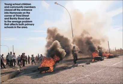  ??  ?? Young school children and community members closed off the entrance into Homevale on the corner of Third Street and Barkly Road due to the sewage problem that affects both primary schools in the area.