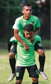  ?? ANGGER BONDAN/JAWA POS ?? SUDAH SIAP: Winger Persebaya Thaufan Hidayat menggendon­g Irfan Jaya dalam latihan conditioni­ng di Lapangan Persebaya (16/4).