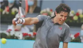  ?? The Associated Press ?? ■ Dominic Thiem of Austria returns the ball to Marcos Giron of the U.S. during Tuesday’s match at the Madrid Open tennis tournament in Madrid, Spain.