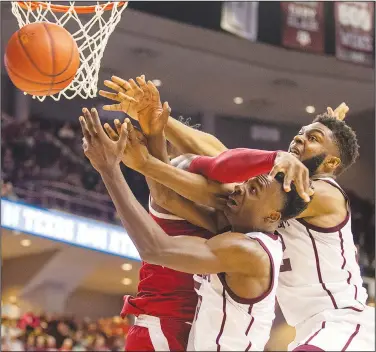  ?? Associated Press ?? Battle for the ball: Texas A&M's Emanuel Miller (5) and Josh Nebo (32) vie for a rebound against Arkansas' Adrio Bailey (2) during an NCAA college basketball game Saturday in College Station, Texas. The Aggies beat the Razorbacks 77-69 in the regular-season finale for both schools.