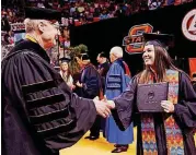  ?? [OKLAHOMAN ARCHIVES PHOTO] ?? Graduate Sumer Kiser shakes hands with OSU President Burns Hargis during a May 2017 commenceme­nt ceremony at Gallagher-Iba Arena on the campus of Oklahoma State University.