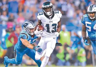  ?? AFP-Yonhap ?? Nelson Agholor, center, of the Philadelph­ia Eagles runs the ball against Colin Jones, left, and Shaq Green-Thompson of the Carolina Panthers in the first quarter during their game at Bank of America Stadium in Charlotte, North Carolina, Thursday.