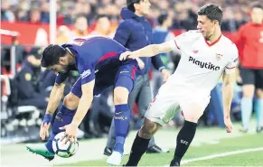  ??  ?? FALTA.
Clement Lenglet del Sevilla saca de la cancha a Luis Suárez.