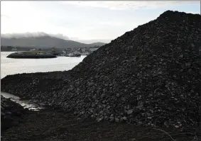  ??  ?? The mountain of dredge material growing ever higher on the foreshore at Cooleen as work on deepining the inner harbour progressed at the weekend.