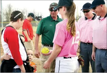  ?? TIMES photograph by Annette Beard ?? Senior Lady Blackhawk Dominique Burwell, No. 12, offered a signed softball to the sons of Chris and Lora McGee Little prior to the Pink Out game Thursday, March 9. Chris Little is an umpire and fellow umpires Ray Burwell and Shaun McCoy joined in...