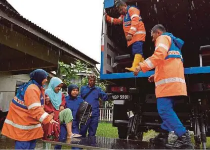  ?? [FOTO BERNAMA] ?? Anggota Angkatan Pertahanan Awam Malaysia membantu memindahka­n mangsa banjir di Kampung Rhu Muda, Marang semalam.