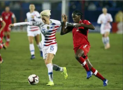  ?? RICHARD W. RODRIGUEZ — THE ASSOCIATED PRESS ?? USA forward Megan Rapinoe, left, and Canada’s Kadeisha Buchanan battle for the ball in the first half of the finals of the CONCACAF Women’s Championsh­ip Wednesday in Frisco, Texas. The U.S. won, 2-0.