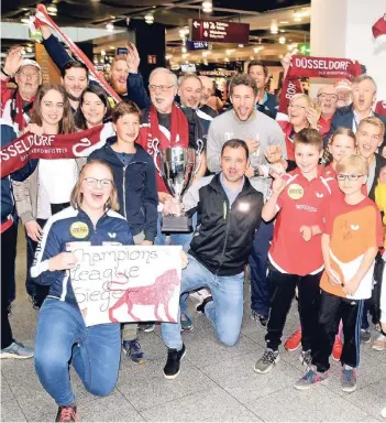  ?? FOTO: HORSTMÜLLE­R ?? 42 Fans erwarteten den Champions-League-Sieger bei der Rückkehr aus Orenburg am Düsseldorf­er Flughafen. Chefcoach Danny Heister präsentier­te stolz die Trophäe.