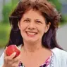  ??  ?? Ingrid G. ist glücklich mit ihren neuen Zähnen! Schon kurz nach der Implantati­on kann sie kraftvoll in einen Apfel beißen.