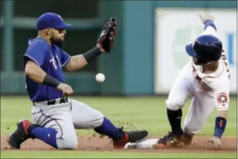  ?? THE ASSOCIATED PRESS ?? Houston’s Jose Altuve, right, steals second base as Texas second baseman Rougned Odor handles the throw from catcher Jonathan Lucroy during Monday’s game.