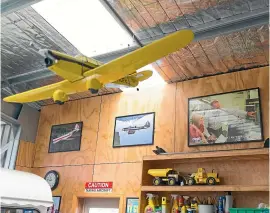  ??  ?? Left, Hickey’s man cave is a curious collection of modern and antique furniture and new and classic vehicles, and all his mates are envious; above, model planes and framed photos are just some of the collectabl­es Hickey has acquired over decades.