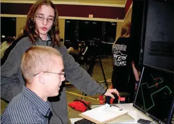  ?? PAT HARRIS ENTERPRISE-LEADER ?? Joseph Grinder and Shelton Sipes look over a game created by Grinder named Tower Defense. Creating games also enables students to learn software that can be used in real career industry applicatio­n in such fields as medical, legal, military and the...