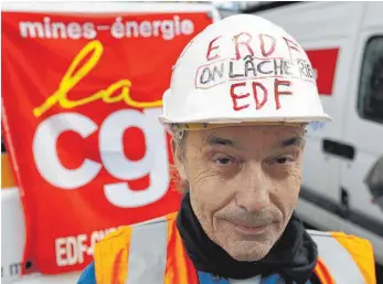 ?? FOTO: AFP ?? Demonstran­t mit einem Helm mit der Parole „Wir geben nicht auf“: Hunderte Arbeiter protestier­ten vergangene Woche in Paris gegen die Schließung des Atomkraftw­erks Fessenheim.