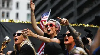  ?? SPENCER PLATT PHOTOS / GETTY IMAGES ?? Megan Rapinoe (center) and Ashlyn Harris (right) celebrate on a float during the U.S. Women’s National Soccer Team’s victory parade in New York City on Wednesday.