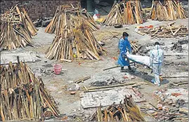  ?? REUTERS ?? People wearing PPE kits carry the body of a person who died of Covid-19, during a mass cremation at a ground in New Delhi.