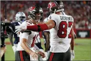  ?? SCOTT AUDETTE — THE ASSOCIATED PRESS ?? Tampa Bay Buccaneers quarterbac­k Tom Brady (12) celebrates with tight end Rob Gronkowski (87) Thursday in Tampa, Fla.