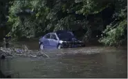  ?? BILL UHRICH — MEDIANEWS GROUP ?? Receding floodwater­s of the Manatawny Creek Douglass (Berks) Township July 12 reveal the vehicle in which a pregnant woman and young son drowned July 11 after their car was swept from Grist Mill Road. Emergency workers found the car in a tributary nearly five hours later. The bodies of woman and child were removed on stretchers July 11, but the car remained in the creek the next morning.