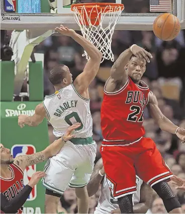  ?? STAFF PHOTOS BY MATT STONE ?? FULL THROTTLE: Celtics guard Avery Bradley battles with Bulls forward Jimmy Butler for a rebound (above) and drives to the basket against center Robin Lopez (below) during yesterday’s game at the Garden. Bradley had 17 points in 26 minutes of the...