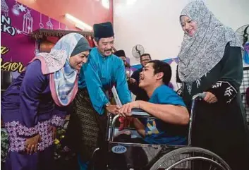  ?? PIC BY MUHAMMAD SULAIMAN ?? Orang Asli
Senator Datuk Isa Ab Hamid (second from left) and Selangor and Federal Territorie­s Jakoa director Norliza Mohammad Basiron (left) having a light moment with wheelchair-bound Muhammad Hafizzudin Mohamad at Jakoa’s Hari Raya Aidilfitri open...