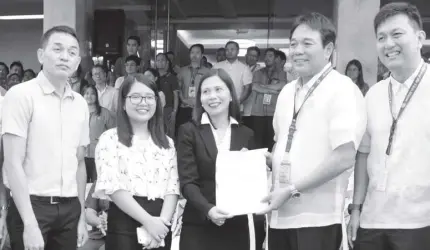  ??  ?? Mayor Olivarez receives the Certificat­e of Confirmati­on from Land Bank of the Philippine AVP for Loans Implementa­tion Department Lani Purnuevo.