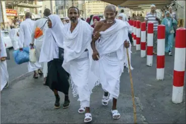  ?? DAR YASIN — THE ASSOCIATED PRESS ?? Muslim pilgrims walk Saturday toward the Grand Mosque, to offer prayers ahead of the annual Hajj pilgrimage, in the Muslim holy city of Mecca, Saudi Arabia. The annual Islamic pilgrimage draws millions of visitors each year, making it the largest yearly gathering of people in the world.