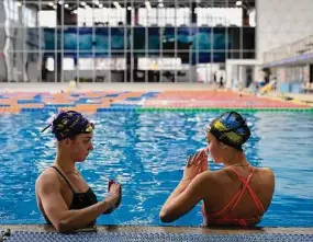  ?? Thibault Camus/Associated Press ?? Ukrainian sisters Maryna, left, and Vladyslava Aleksiiva speak during a practice session in Kyiv, Ukraine. The path to the 2024 Paris Olympics for Ukrainian athletes is clouded by war, anger and pain. Russian bombardmen­ts have wrecked training venues. Air raids disrupt training sessions. Athletes have lost family members and friends. Or they worry that they will.