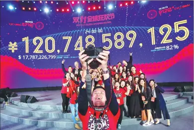  ?? XINHUA ?? Staff of Alibaba’s online shopping platform Tmall cheer as its sales volume surpasses 120 billion yuan during the Singles Day shopping spree in 2016.