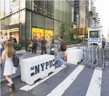 ?? Richard Drew / Associated Press ?? Pedestrian­s navigate a jumble of makeshift police barriers around Trump Tower in New York.
